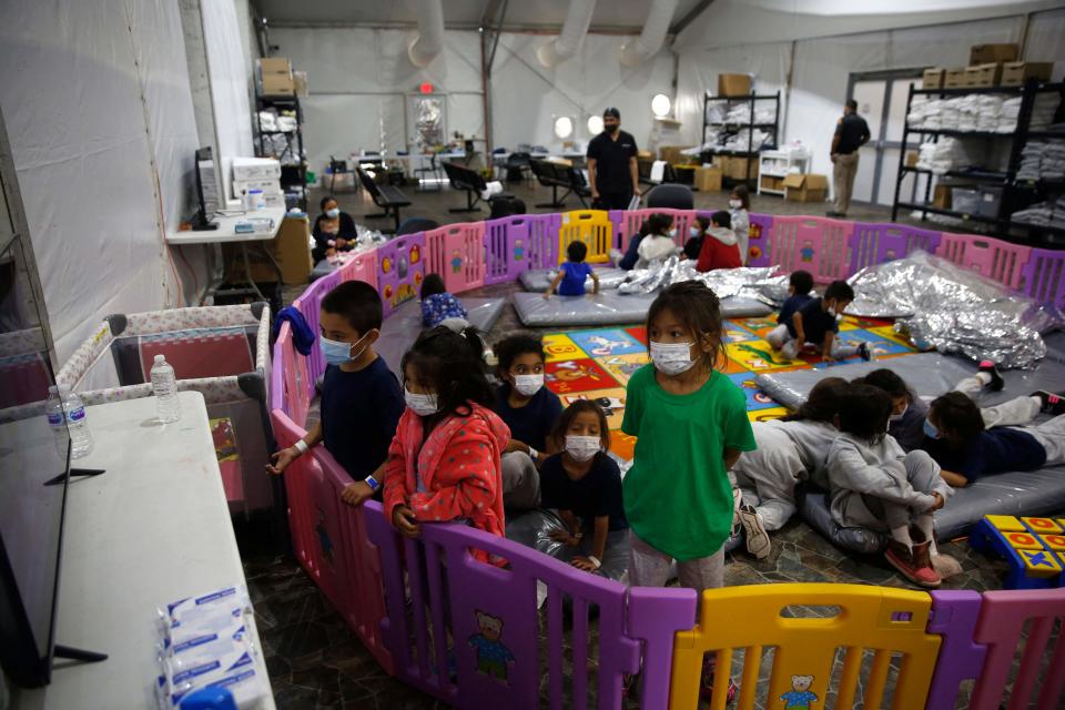 Young unaccompanied migrants, ages 3-9 watch TV inside a playpen at the Donna Department of Homeland Security holding facility, the main detention center for unaccompanied children in the Rio Grande Valley in Donna, Texas, March 30, 2021. The youngest of the unaccompanied minors are kept separate from the rest of the detainees. (Photo by Dario Lopez-Mills / POOL / AFP)