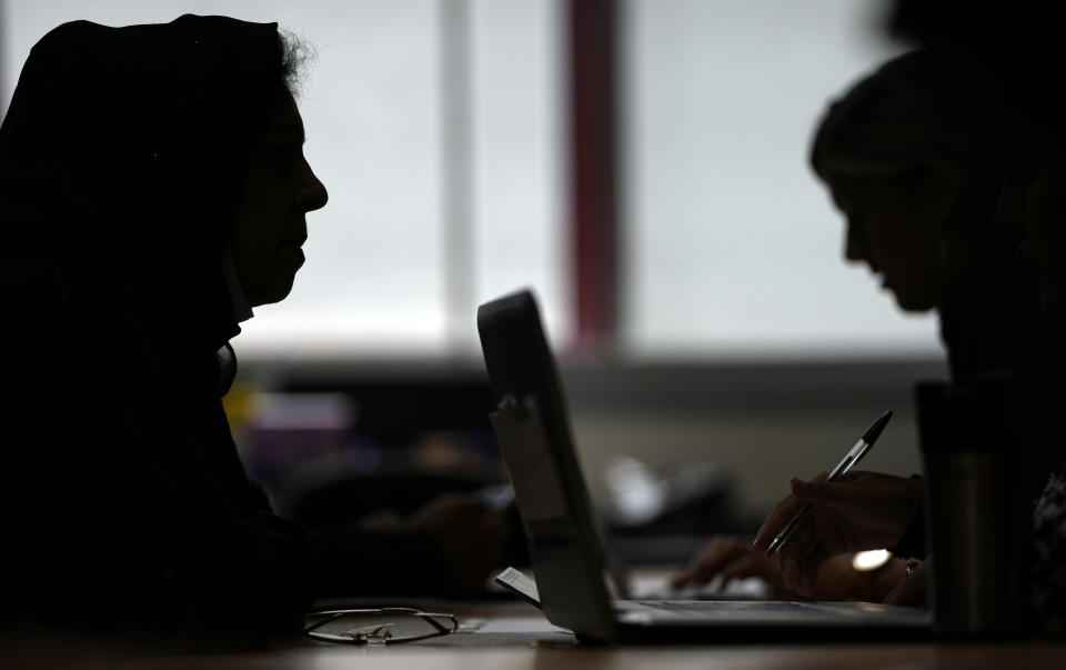 Volunteers help Afghan refugees and British citizens who have relatives and family in Afghanistan, who they will try to locate and bring out of the country, at the Afghanistan and Central Asia Association in London, Friday, Aug. 27, 2021.(AP Photo/Alastair Grant)