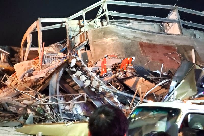 Rescue workers are seen on the site where a hotel being used for the novel coronavirus quarantine collapsed in the southeast Chinese port city of Quanzhou, Fujian