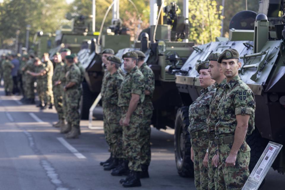 Serbian army soldiers stand to attention in front of armored personnel carriers on display as part of a newly established "Serbian Unity Day" holiday in Belgrade, Serbia, Wednesday, Sept. 15, 2021. Serbia has kicked off a new holiday celebrating national unity with a display of military power, triggering unease among its neighbors. The new holiday comes decades after similar calls for unity led to the bloody wars in the Balkans in the 1990s. Serbs in the region were told to display thousands of red, blue and white national flags wherever they live in the region or the world to mark “The Day of Serb Unity, Freedom and the National Flag.” Serbian officials are calling for the creation of a “Serb World,” or political unification of an estimated 1.3 million Serbs who live in Bosnia, Montenegro, Kosovo and Croatia with Serbia. (AP Photo/Marko Drobnjakovic)