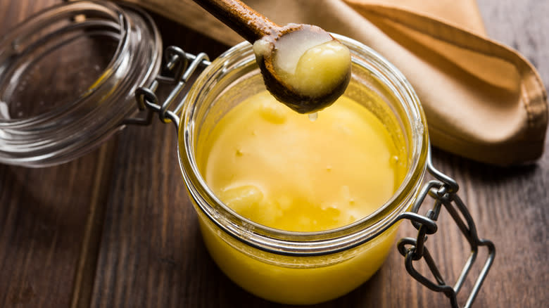 Opened glass jar of clarified butter