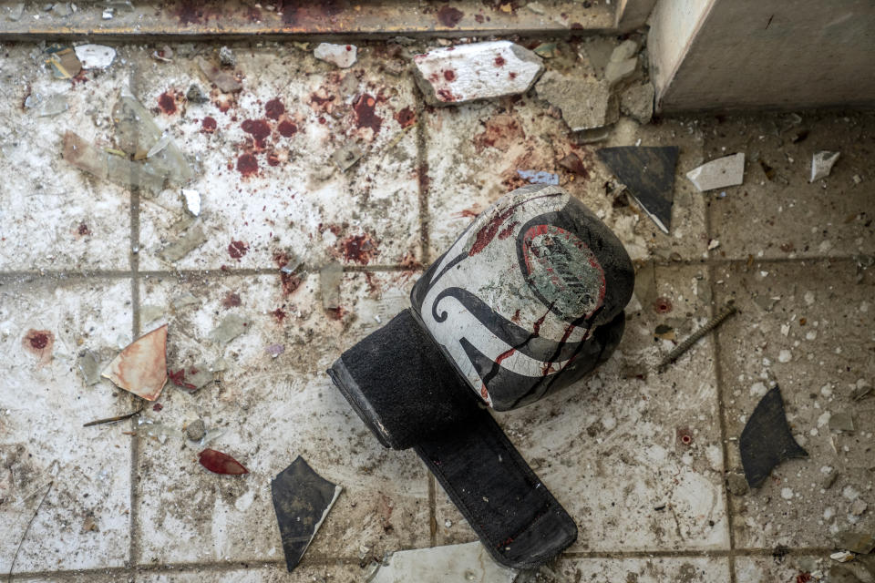 A bloody boxing glove belonging to one of the victims of the Thursday night's blast is seen on the ground of the sports club, in the west of Kabul, Afghanistan, Friday, Oct. 27, 2023. The blast killed some people and injured others in a Shiite neighbourhood in the Afghan capital Kabul. (AP Photo/Ebrahim Noroozi)