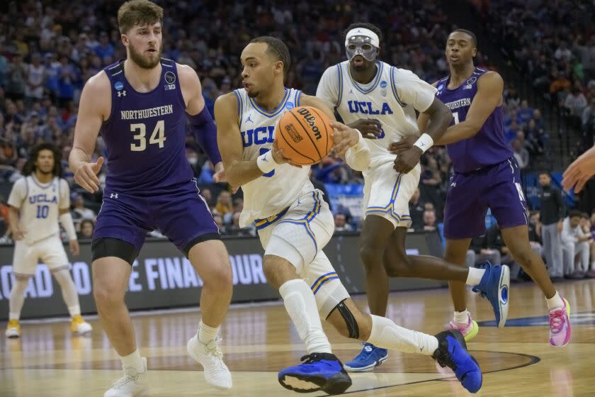 UCLA guard Amari Bailey drives to the basket past Northwestern center Matthew Nicholson (34) during the second half.