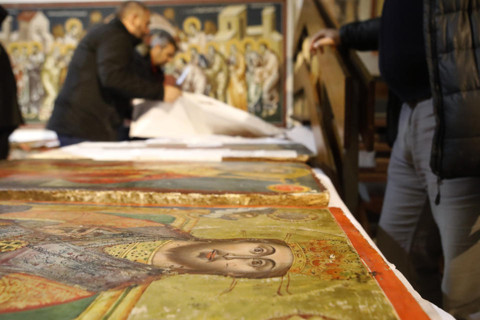 Museum workers unpack icons returned from Albania at the National museum in Skopje, North Macedonia, late Friday, Dec. 15, 2023. Albania on Friday returned 20 icons to neighboring North Macedonia that were stolen a decade ago. (AP Photo/Boris Grdanoski)