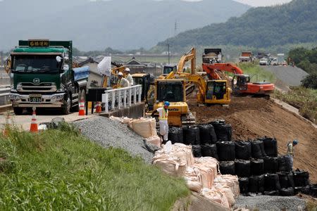 Workers conduct repair work on a destroyed embankment along Odagawa river in Mabi town in Kurashiki, Okayama Prefecture, Japan, July 13, 2018. REUTERS/Issei Kato