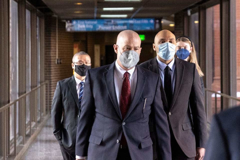 Former Minneapolis police officers J. Alexander Kueng, right, and Tou Thao, left, arrive with attorney Thomas Plunkett, center, at U.S. District Court in St. Paul, Minn., on Jan. 11. Kueng, Thao and another former officer are charged with federal civil rights violations in George Floyd's death.