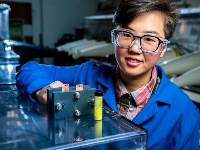 El investigador de baterías de flujo Ruozhu Feng posa con los ingredientes de una batería de energía de red de larga duración (Andrea Starr/Laboratorio Nacional del Noroeste del Pacífico)
