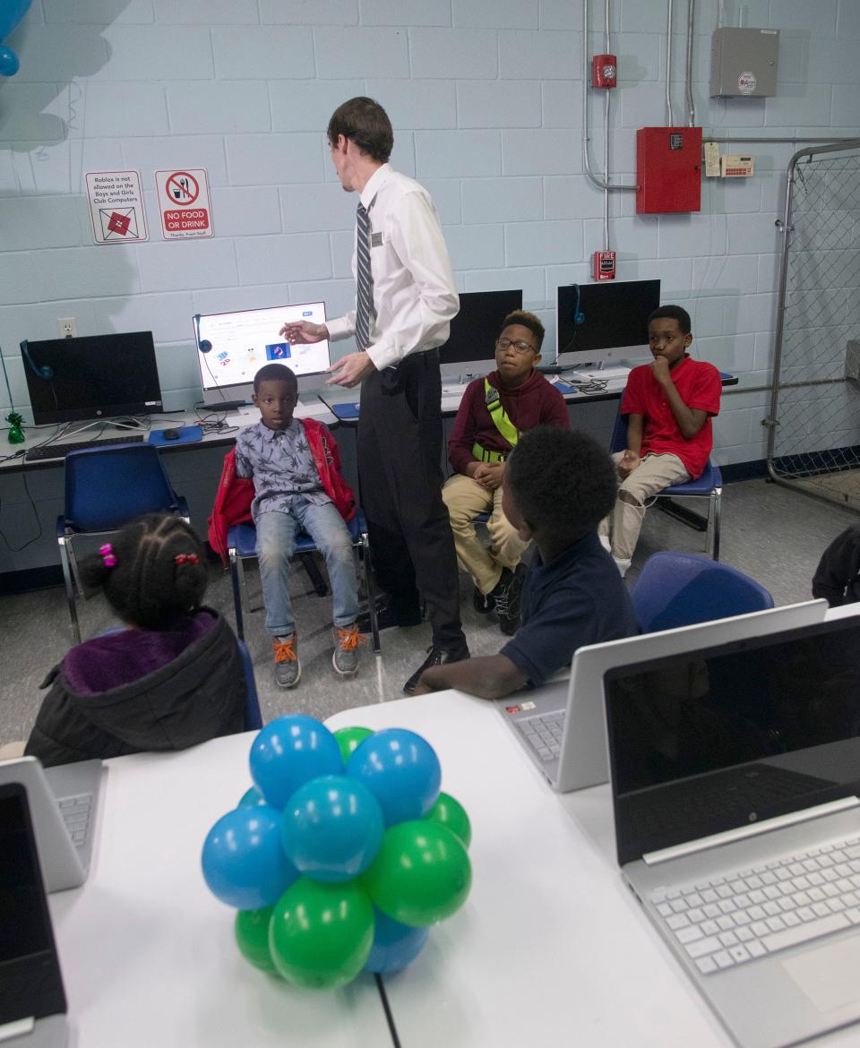 Sam Roberts shows a group of kids at the Boys and Girls Clubs of the Emerald Coast how to use the 3D printer at the new Cox Technology Innovation Lab in Pensacola on Wednesday, Dec. 30, 2022. The $20,000 collaborative workspace features new computer workstations, enhanced digital learning, S.T.E.A.M. focus areas and two 3D printers.