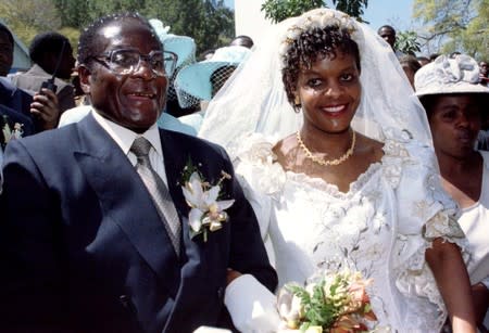 FILE PHOTO: President Robert Mugabe and new wife Grace leave the Kutama Catholic Church in Zimbabwe August 17, 1996 after exchanging their wedding vows.