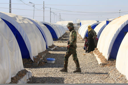 A member of Iraqi security forces walks at the refugee camp in Hammam Ali, south of Mosul, Iraq February 24, 2017. REUTERS/Alaa Al-Marjani