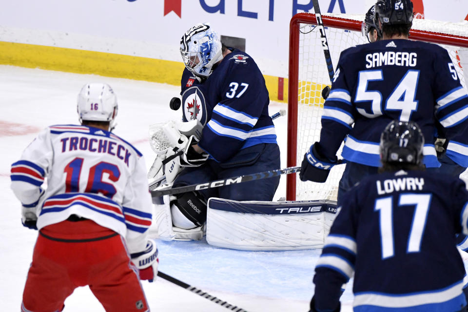 Winnipeg Jets' goaltender Connor Hellebuyck (37) makes a save against a New York Rangers shot during third-period NHL hockey game action in Winnipeg, Manitoba, Monday, Oct. 30, 2023. (Fred Greenslade/The Canadian Press via AP)