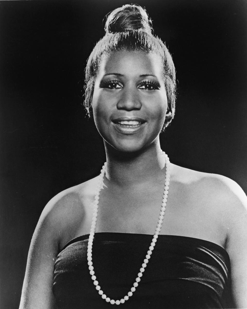 <p>Aretha Franklin wears a strapless dress, single pearl necklace, and slick topknot hairdo with lush eyelashes. (Photo by Hulton Archive/Getty Images) </p>