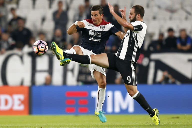 Juventus' Argentinian forward Gonzalo Higuain (L) vies with Cagliari's midfielder Simone Padoin during the Italian Serie football match on September 21, 2016