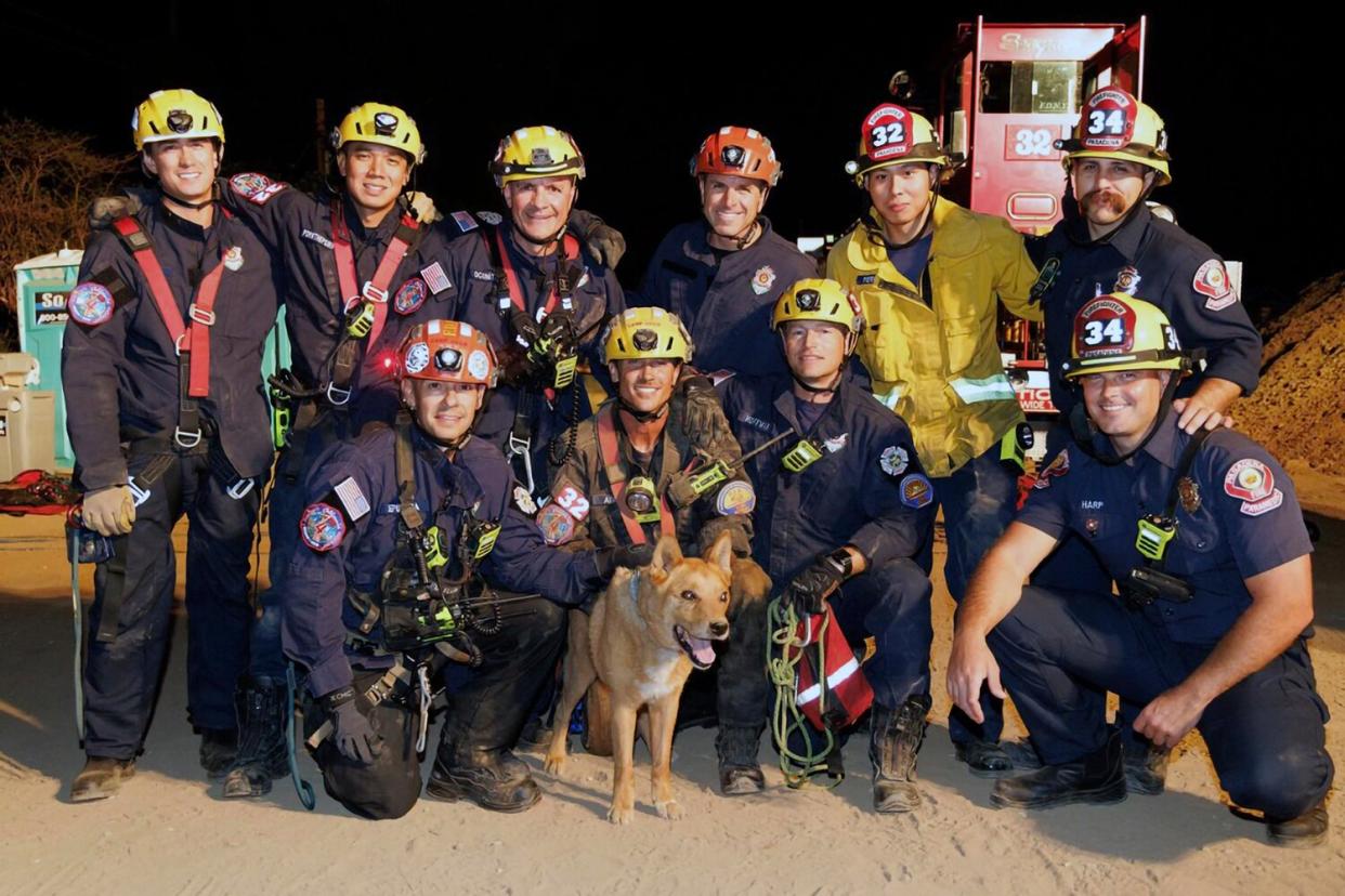 This image provided by the Pasadena Fire Department showing firefighters pose with a Cesar a blind dog that was rescued from a hold in Pasadena, Calif. on Tuesday, Sept. 20, 2022.