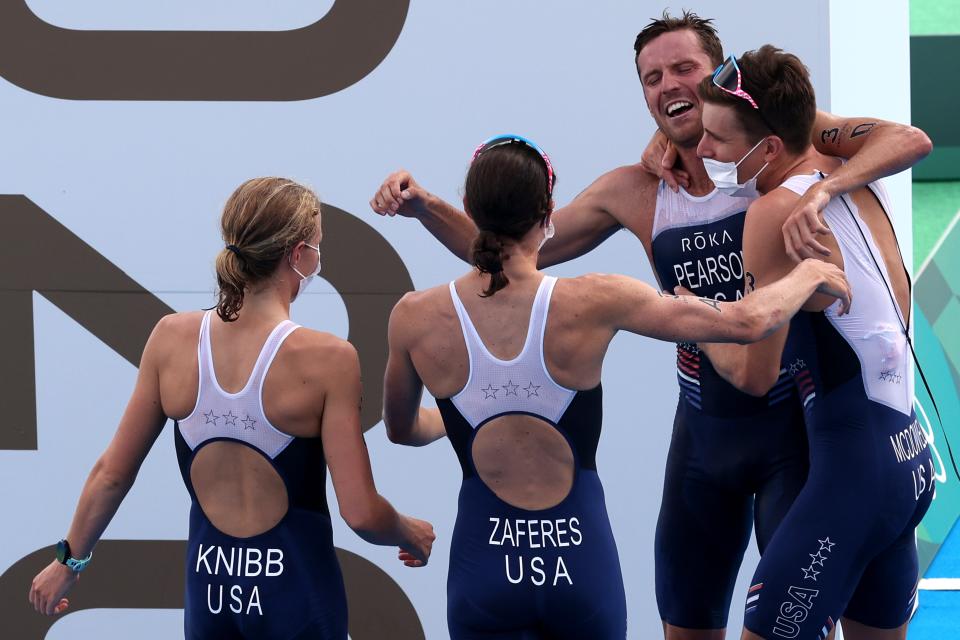 Morgan Pearson celebrates with teammates Katie Zaferes, Kevin McDowell and Taylor Knibb after the USA wins silver in triathlon mixed relay.