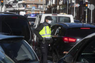 Police mount a checkpoint on the outskirts of Madrid, Spain, Saturday, Oct. 3, 2020. Madrid is on a partial lockdown complying with an order from the Spanish government due to the high COVID-19 cases but determined to fight it in the courts. Measures that ban all nonessential trips in and out of the capital and nine of its suburbs, covering around 4.8 million people. (AP Photo/Paul White)