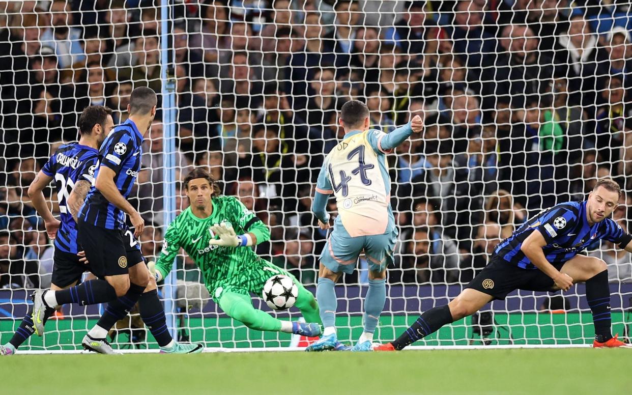 Inter goalkeeper Yann Sommer (C facing) dives to make a save from a shot on goal by Phil Foden (C) of Manchester City