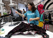 In this Tuesday, March 12, 2019, photo Jasmine Valladares enters measurements as she itemizes clothing at the ThredUp sorting facility in Phoenix. Charitable organizations like Goodwill have cited how Marie Kondo’s popular Netflix series, “Tidying up with Marie Kondo” has led to a surge of donations. And sites like OfferUp and thredUP also note an uptick in the number of items being sent to them for sale. (AP Photo/Matt York)