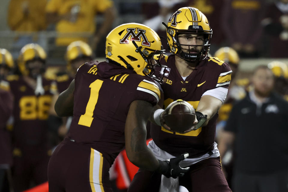 Minnesota quarterback Max Brosmer, right, hands the ball to running back Darius Taylor (1) during the first half of an NCAA college football game against Southern California, Saturday, Oct. 5, 2024, in Minneapolis. (AP Photo/Ellen Schmidt)