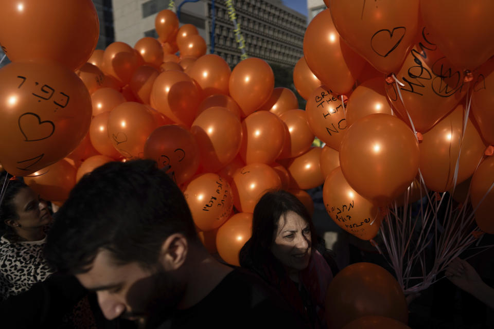 Demonstrators hold orange balloons at a rally in solidarity with Kfir Bibas, an Israeli boy who spent his first birthday Thursday in Hamas captivity in the Gaza Strip, in Tel Aviv, Israel, Thursday, Jan. 18, 2024. The plight of Bibas, the youngest hostage held by Hamas, has captured the nation's attention and drawn attention to the government's failure to bring home more than 100 hostages still held by Hamas after more than three months of war. (AP Photo/Oded Balilty)