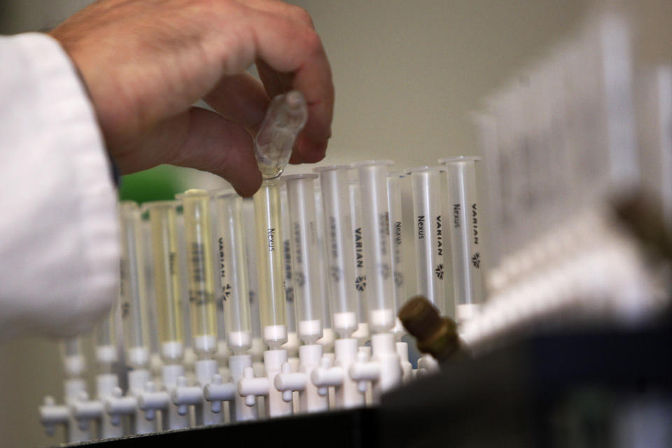 FILE - In this Feb. 5, 2010, file photo, a laboratory technician prepares samples of urine for doping tests during a media open day, at the King's College Drug Control Centre in London. The World Anti-Doping Agency is looking to artificial intelligence as a new way to detect athletes who cheat, it is revealed Tuesday May 26, 2020, funding four projects in Canada and Germany, looking at whether AI could spot signs of drug use. (AP Photo/Sang Tan, File)