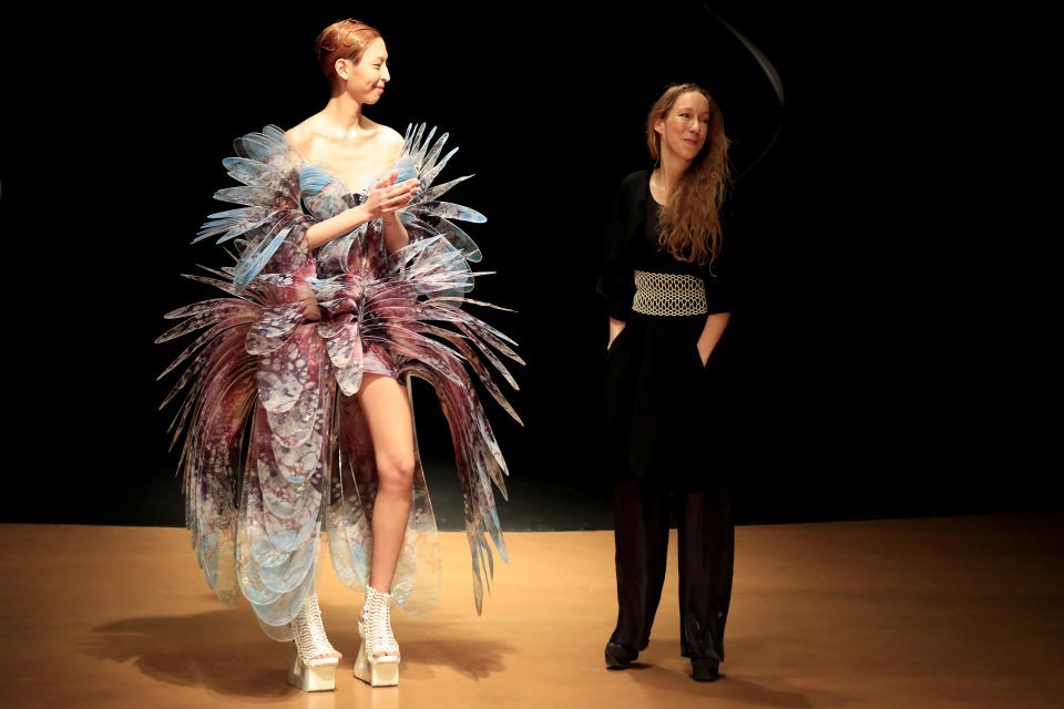 Dutch designer Iris Van Herpen, right, acknowledges audience applause after the presentation of her Haute Couture Spring/Summer 2020 fashion collection Monday Jan.20, 2020 in Paris (AP Photo/Michel Euler)