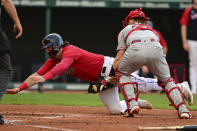 Cleveland Guardians' Austin Hedges sides to score a run as Los Angeles Angels catcher Max Stassi misplays the ball during the second inning of a baseball game, Monday, Sept. 12, 2022, in Cleveland. (AP Photo/David Dermer)