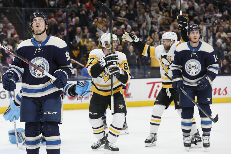 Pittsburgh Penguins' Sidney Crosby, center left, and Bryan Rust, center right, celebrate their goal as Columbus Blue Jackets' Jack Roslovic, left, and Gustav Nyquist, react during third period of an NHL hockey game Sunday, Feb. 27, 2022, in Columbus, Ohio. (AP Photo/Jay LaPrete)