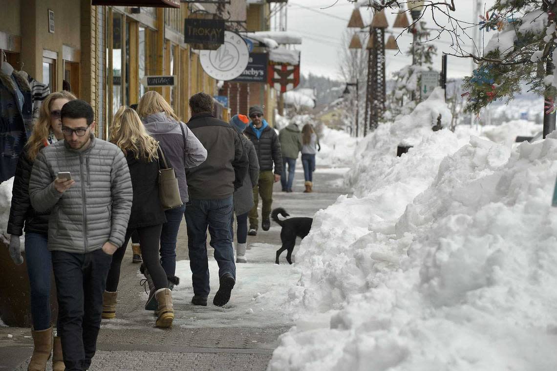 Shoppers walk along the sidewalk beside the snow piled up along Donner Pass Road in central Truckee in 2017. Tourism in the winter and summer are the lifeblood of the Tahoe-adjacent community. Donner Pass Road, the artery that preceded Interstate 80, faced weeks of closures during last year’s parade of winter storms. Randall Benton/Sacramento Bee file