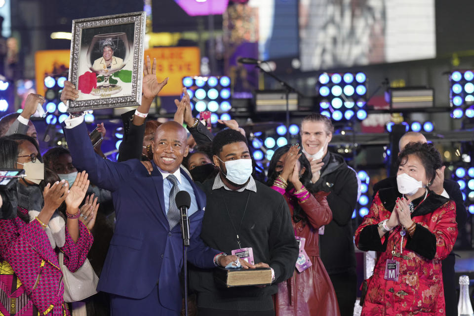 FILE — Eric Adams holds up a framed image of his mother at his mayoral swearing-in ceremony, during the Times Square New Year's Eve celebration, Jan. 1, 2022, in New York. New York City's new mayor is a hands-on politician and nightlife enthusiast who at times has approached the job like a showman or a therapist, proclaiming the benefits of medication, the glory of vegetables and the "swagger" he says he brings to the city.(Photo by Ben Hider/Invision/AP, File)