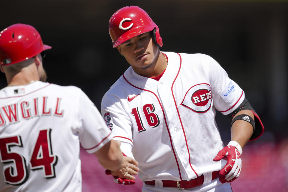 Cincinnati Reds' Noelvi Marte, right, high-fives first base coach Collin Cowgill after hitting an RBI single during the fourth inning of the first game of a baseball doubleheader against the Chicago Cubs in Cincinnati, Friday, Sep. 1, 2023. (AP Photo/Aaron Doster)