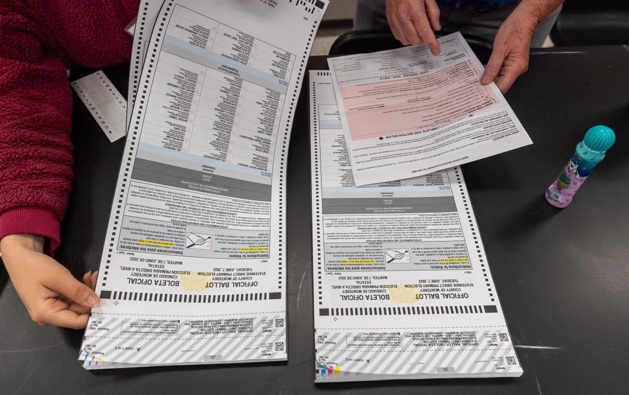 A polling inspector helps another poll worker choose the ballot for a person voting in person at the La Paz Middle School polling place for the 2022 California Primary elections in Salinas, Calif., on Tuesday, June 7, 2022. 