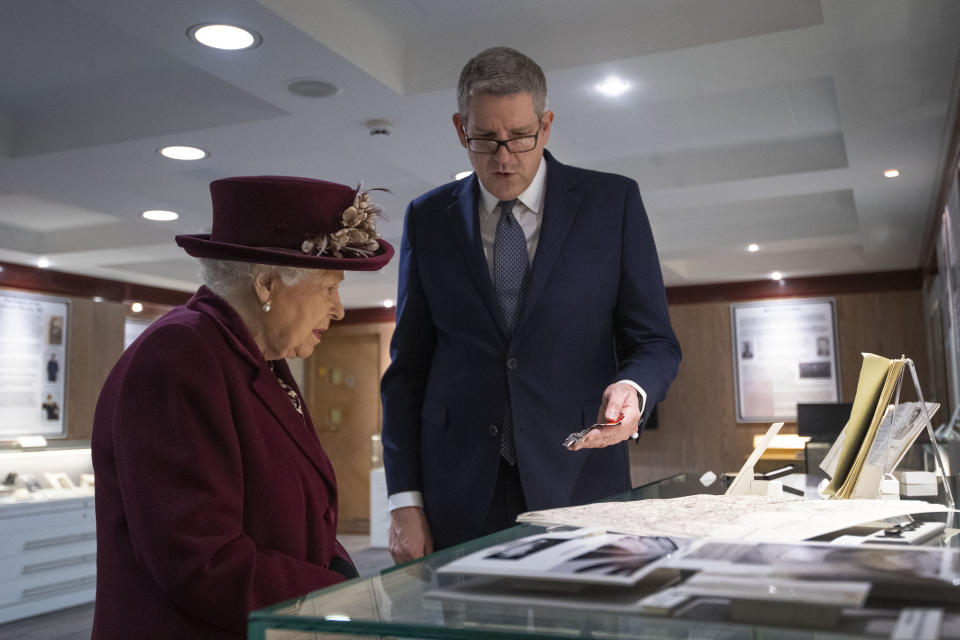 Queen Elizabeth II looks at artifacts relating to MI5 D-Day operations with Director General Andrew Parker during a visit to the headquarters of MI5 at Thames House in London.