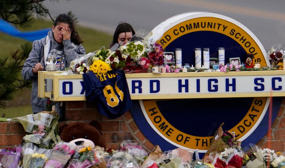 The cold winds did not discourage community members from bringing flowers and praying at a makeshift memorial at Oxford High School Thursday, Dec. 2, 2021, after four students were shot dead and several injured when a fellow student allegedly opened fire on the students and teachers at the school earlier in the week.