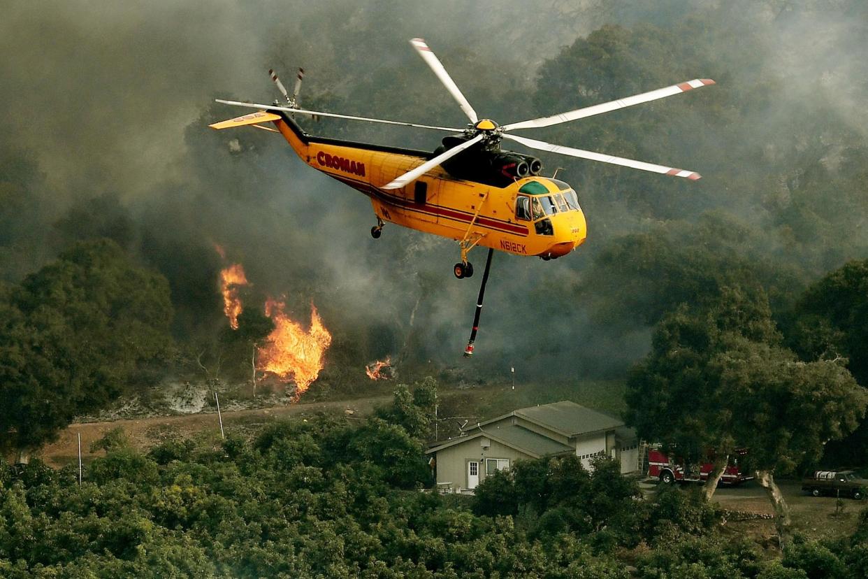 Huge blaze: A firefighting helicopter battles to contain flames: AFP