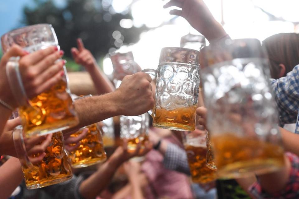 Visitors of the Oktoberfest beer festival clink their beer glasses on September 24, 2017 at the Theresienwiese fair grounds in Munich, southern Germany.