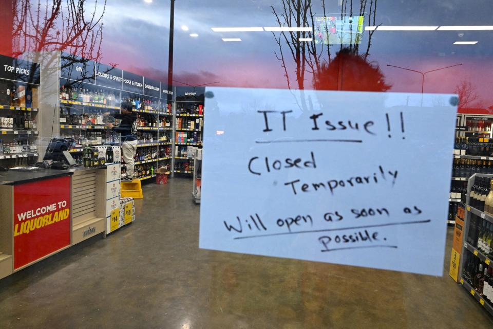 A sign notifies customers of a temporary closure due to IT issues at a Liquorland store in Canberra, Australia, July 19, 2024.