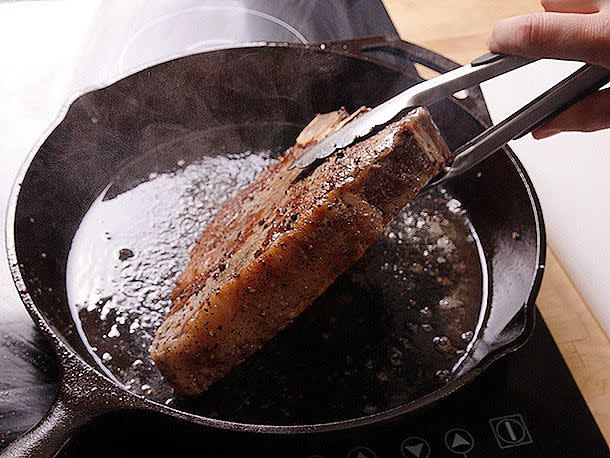 Photograph: J. Kenji Lopez-Alt Use tongs or a spatula to flip your meat, and do it frequently. This will help it cook more evenly and a little faster. Make sure to grip the bone with the tongs, NOT the meat, which can cause it to tear away from the bone.