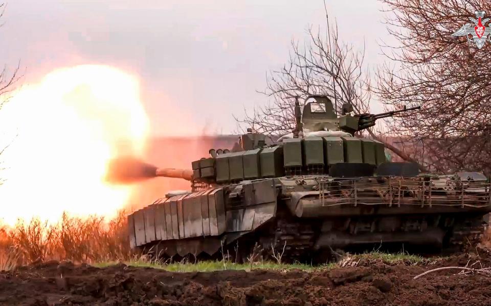 A Russian tank fires its cannon at Ukrainian troops from a position near the border with Ukraine in the Belgorod region