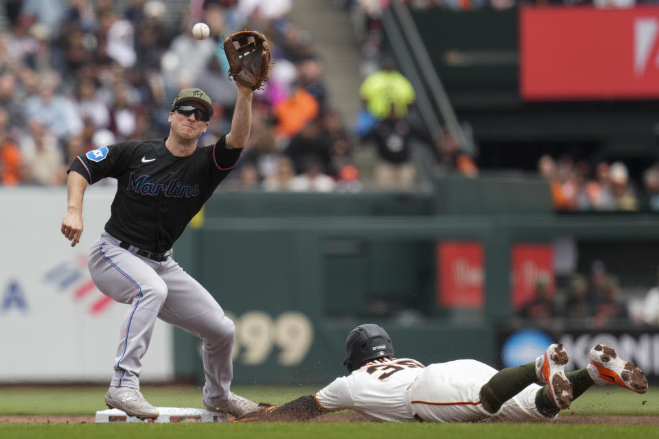 Miami Marlins shortstop Joey Wendle, left, catches a throw from catcher Nick Fortes as San Francisco Giants' Thairo Estrada, right, steals second base during the first inning of a baseball game in San Francisco, Saturday, May 20, 2023. (AP Photo/Godofredo A. Vásquez)