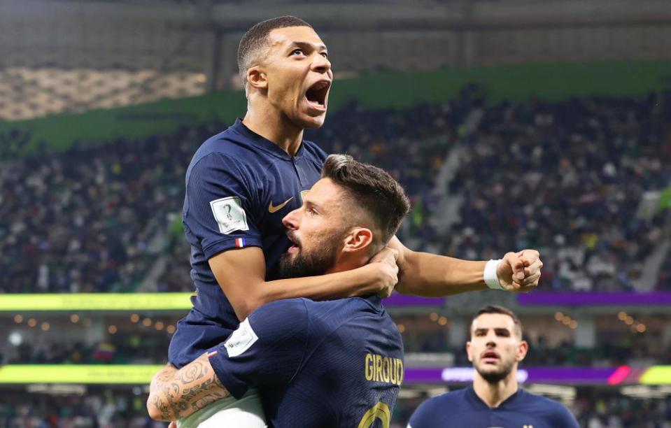 Olivier Giroud of France celebrates with teammate Kylian Mbappé at the 2022 World Cup.