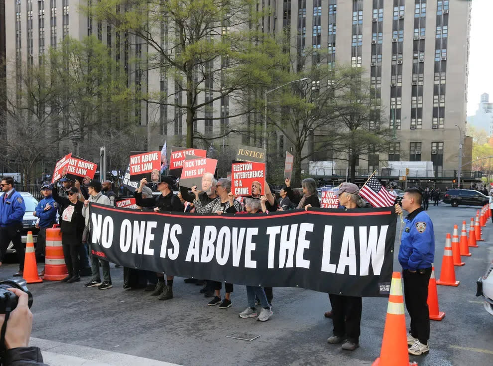 Protesters express their opinion April 15 outside N.Y. Criminal Court, where former President Donald Trump is on trial on federal charges.