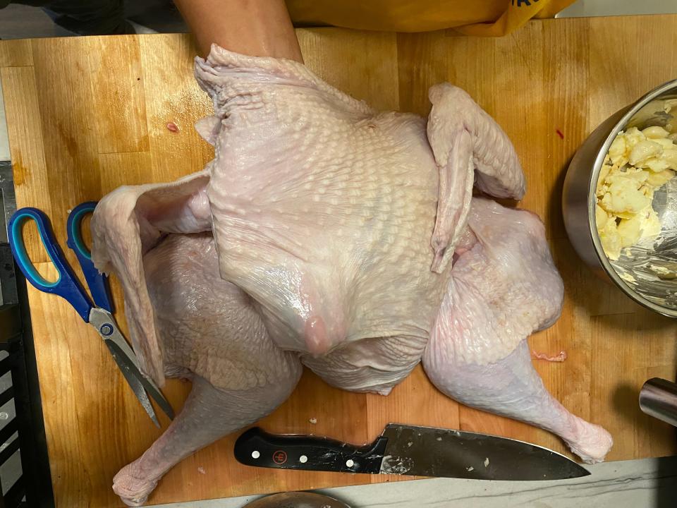 A flattened turkey getting buttered.