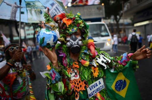 An activist with a Brazilian national flag and a sign reading "Long live nature" takes part in the "Global March" in Rio de Janeiro, Brazil, in the framework of the UN Rio+20 Conference on Sustainable Development