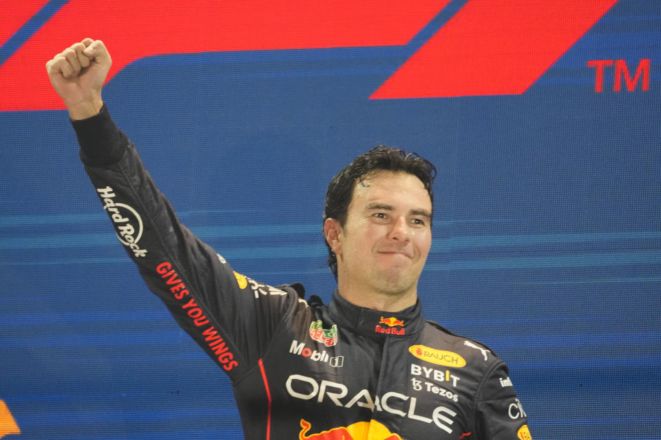 Red Bull driver Sergio Perez of Mexico celebrates on the podium after winning the Singapore Formula One Grand Prix, at the Marina Bay City Circuit in Singapore, Sunday, Oct.2, 2022. (AP Photo/Vincent Thian)