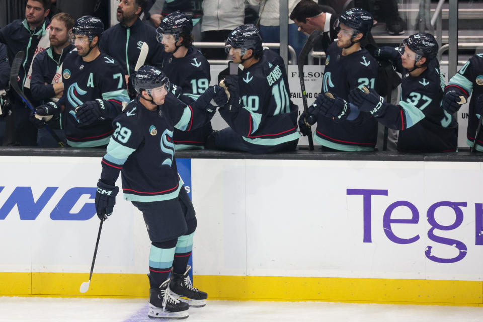 Seattle Kraken defenseman Vince Dunn (29) celebrates with the bench after his goal during the second period of an NHL hockey game against the Carolina Hurricanes, Thursday, Oct. 19, 2023, in Seattle. (AP Photo/Jason Redmond)
