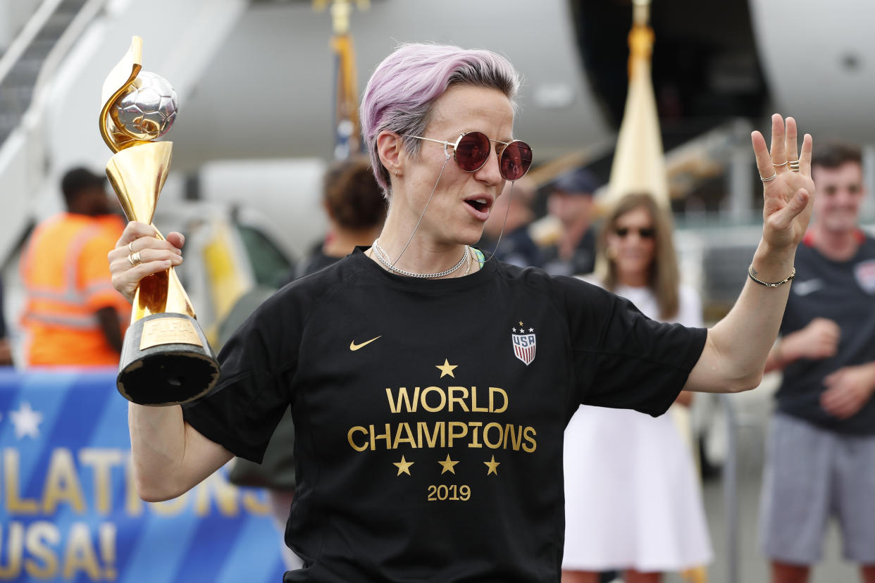 Megan Rapinoe holds the Women's World Cup trophy after she and other members of the U.S. women's national soccer team, winners of a fourth Women's World Cup, celebrated after arriving at Newark Liberty International Airport, Monday, July 8, 2019, in Newark, N.J. (AP Photo/Kathy Willens)