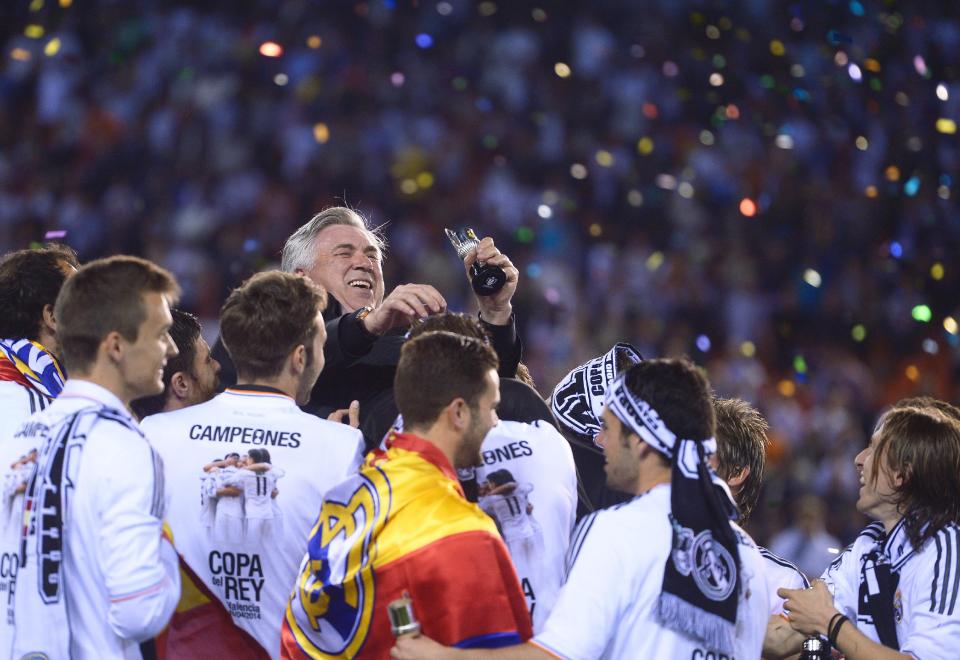 Real's players throw Real's Carlo Ancelotti in the air at the end of the final of the Copa del Rey between FC Barcelona and Real Madrid at the Mestalla stadium in Valencia, Spain, Wednesday, April 16, 2014. Real defeated Barcelona 2-1. (AP Photo/Manu Fernandez)