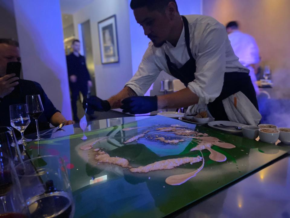 someone painting dessert onto a table