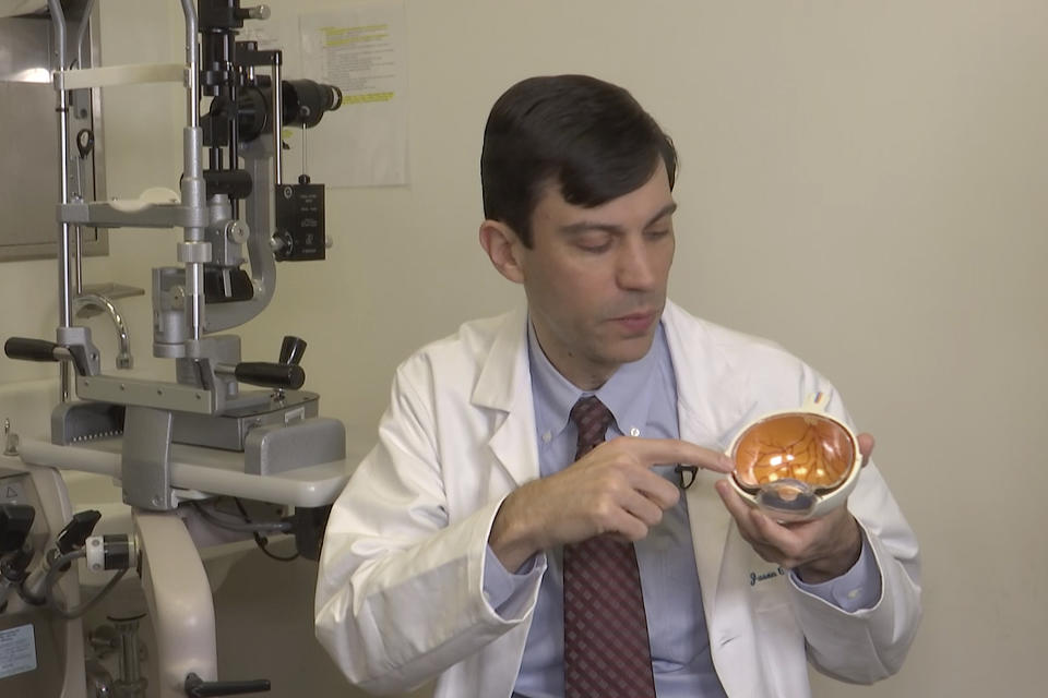 Dr. Jason Comander, inherited retinal disorder specialist at Massachusetts Eye and Ear Infirmary in Boston points to a model of an eye during an interview on Jan. 8, 2020. Comander's hospital plans to enroll patients in a gene editing treatment for blindness study. He said it marks “a new era in medicine” using a technology that “makes editing DNA much easier and much more effective.” (AP Photo/Rodrique Ngowi)